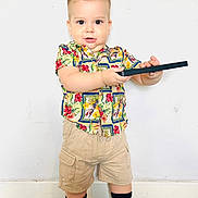 Matias joined the competition — help win amazing prizes! toddler, child, boy, standing, colorful_shirt, floral_pattern, beige_shorts, black_object, indoor, white_wall, carpet, socks, cute, curious, young_child, portrait, casual_clothing, playful, hands, feet
