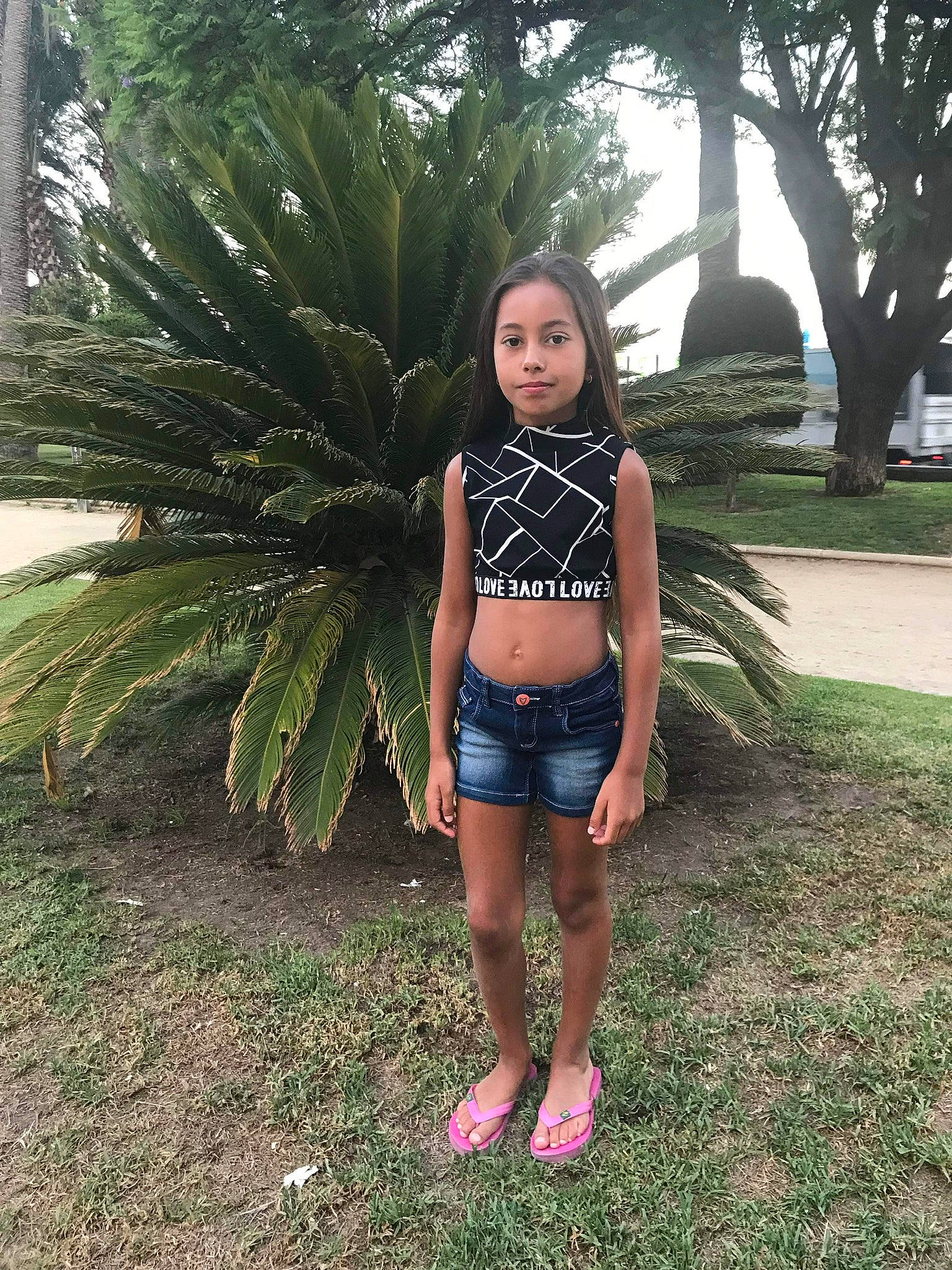 Kellya participe au concours pour gagner de l'argent avec cette photo : arecales, denim, foot, fun, grass, human_leg, jeans, knee, leisure, long_hair, navel, person, plant, sandal, shorts, shrub, terrestrial_plant, thigh, tree, trunk