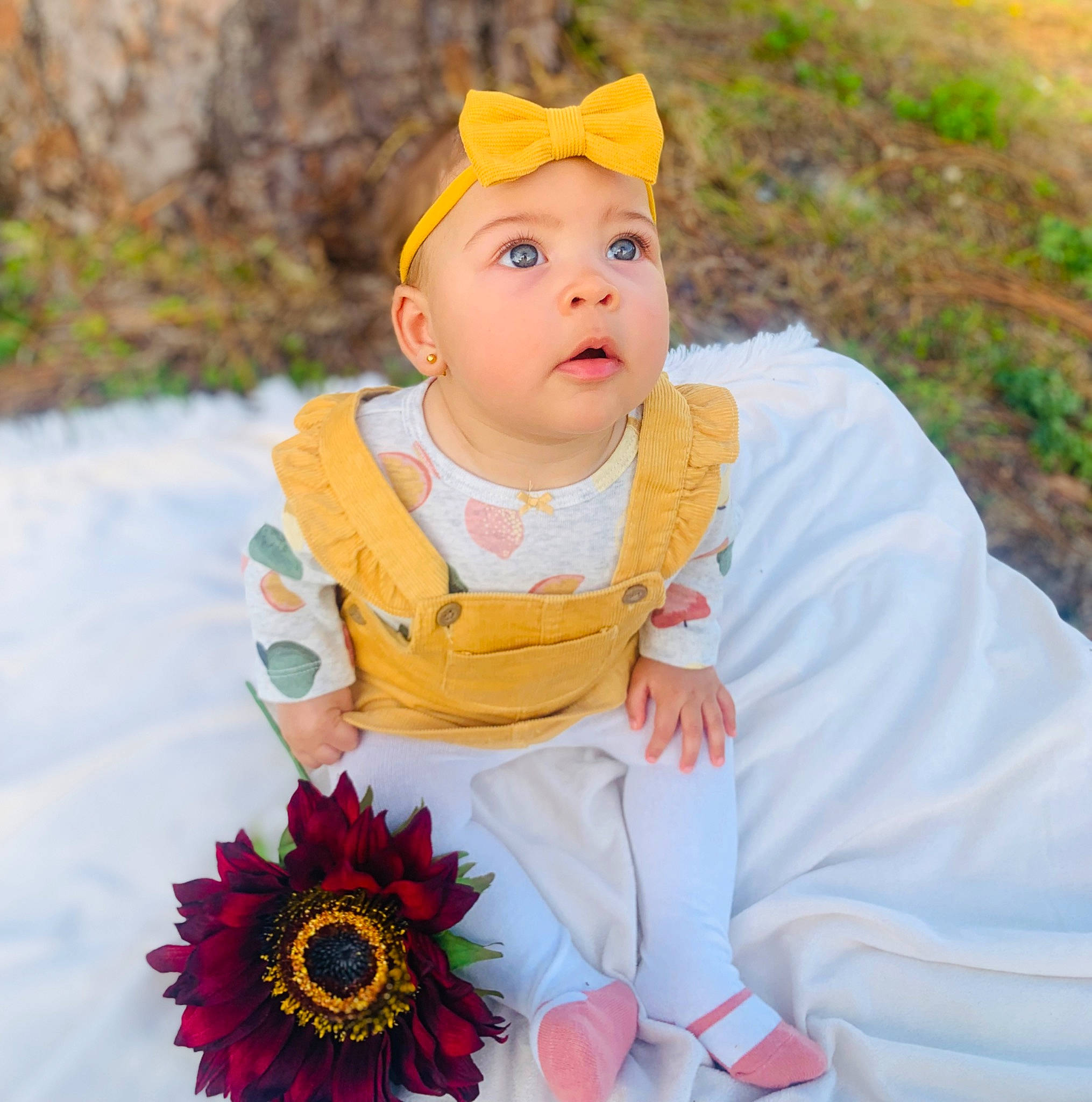 Ariya is registered to the contest to win money with this photo: baby, baby_toddler_clothing, cap, child, dress, fashion_accessory, flower, fun, grass, happy, headwear, jewellery, leisure, pattern, people_in_nature, person, petal, portrait_photography, sitting, sleeve