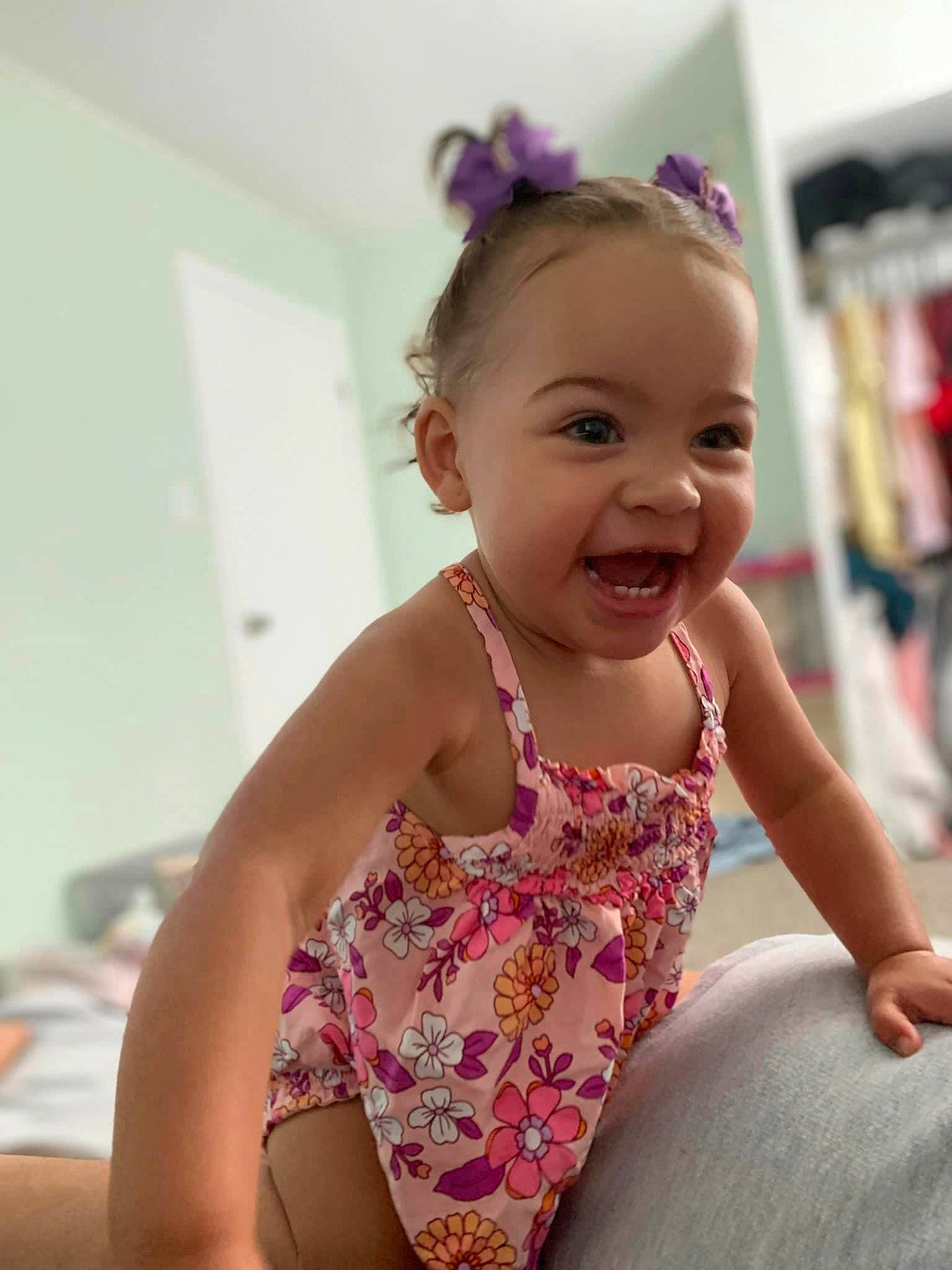 Ariya is registered to the contest to win money with this photo: baby_toddler_clothing, blond, child, chin, face, facial_expression, fun, happy, human_leg, iris, magenta, person, pink, purple, shelf, skin, sleeve, smile, sportswear, thigh