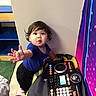 Isaiah is registered to the contest to win money with this photo: toddler, child, indoor, toy, dj_mixer, colorful, curious, reaching, person, young_child, play, floor, blue_shirt, black_pants, hair, expression, wall, carpet, furniture, technology