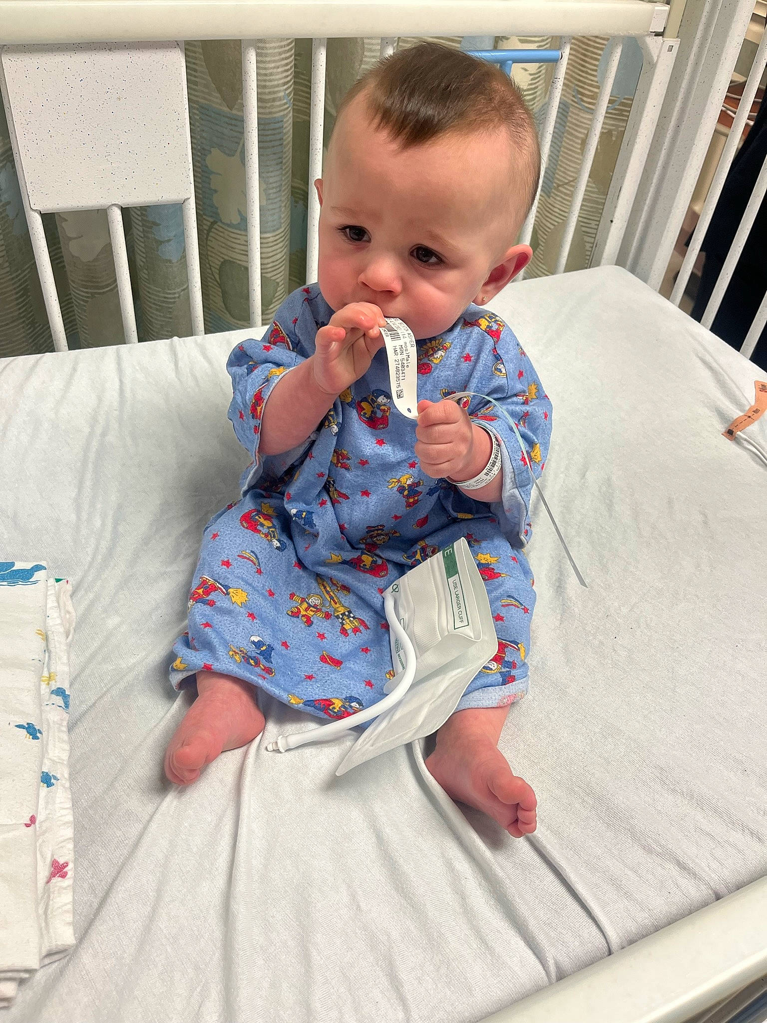 Brixton is registered to the contest to win money with this photo: baby, baby_products, baby_toddler_clothing, child, comfort, dress, flooring, fun, hairstyle, linens, pattern, person, play, room, sitting, skin, sleeve, standing, t_shirt, textile