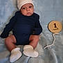 Ja'Cory is registered to the contest to win money with this photo: baby, infant, newborn, blue_blanket, white_hat, white_socks, navy_clothing, wooden_sign, 1_month, milestone, lying_down, cute, face, legs, feet, soft_texture, portrait, indoors, child, small