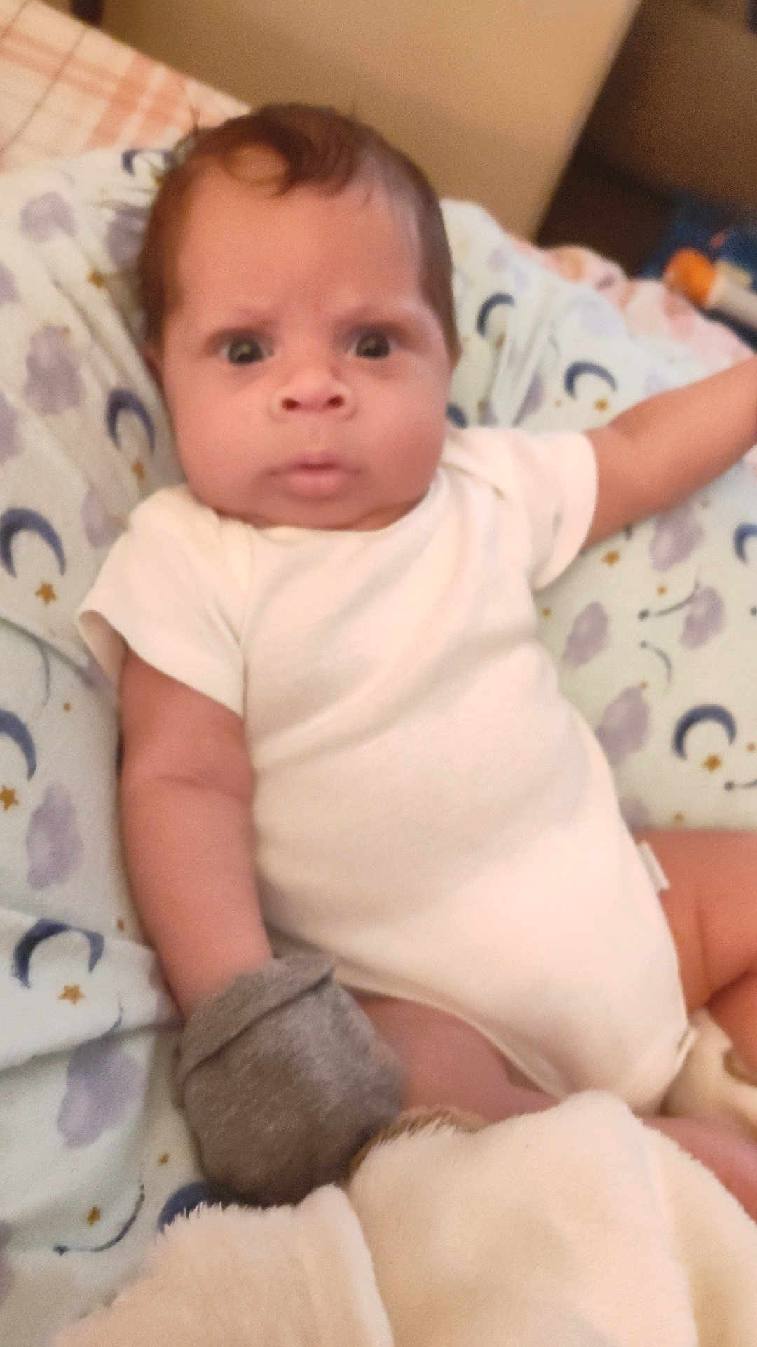 Ja'Cory is registered to the contest to win money with this photo: baby, infant, onesie, mitten, blanket, face, expression, wide_eyes, soft_fabric, bed, sleepwear, person, child, cute, indoor, portrait, newborn, resting, young, curious
