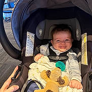 Raine joined the competition — help win amazing prizes! baby, car_seat, smiling, toy, plush_dog, pacifier, hand, blanket, clothing, infant, child, seatbelt, indoor, person, cute, happy, face, portrait, baby_girl, baby_boy