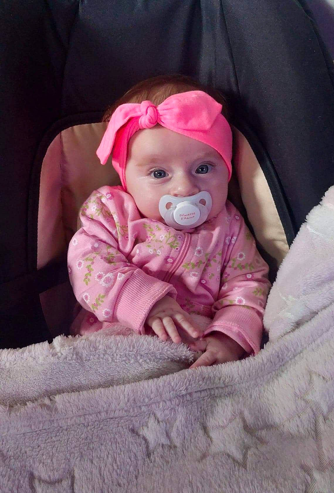 Mya participe au concours pour gagner de l'argent avec cette photo : baby, baby_products, baby_safety, baby_toddler_clothing, cheek, child, comfort, eye, eyebrow, headwear, iris, linens, lip, magenta, mouth, person, pink, sitting, skin, sleeve