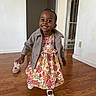 casual, child, cute, dress, floor, floral, footwear, girl, happy, home, indoor, jacket, person, portrait, slipper, smiling, toddler, walking, wooden_floor, young_child