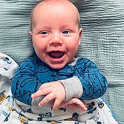 Rowan joined the competition — help win amazing prizes! baby, infant, smiling, blue_pajamas, blanket, face, eyes, mouth, hands, cheeks, lying_down, bedding, cozy, happy, portrait, newborn, soft_texture, cute, skin, gaze