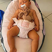 Imany participe au concours pour gagner de l'argent avec cette photo : baby, sleeping, pacifier, plush_toy, baby_lounger, diaper, floor, tile, couch, infant, child, relaxing, indoor, comfort, rest, cute, soft_toy, nursery, peaceful, toddler