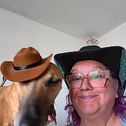 Toby is registered to the contest to win money with this photo: woman, dog, hat, glasses, smile, indoor, portrait, pet, blur, face, human, accessory, brown_hat, black_hat, happy, casual, friendship, fun, closeup, person
