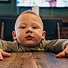 Westley joined the competition — help win amazing prizes! baby, child, face, hands, table, indoor, curious, chubby_cheeks, wooden_surface, blurred_background, seated, casual_clothing, expression, portrait, young_child, cute, looking, person, furniture, cozy