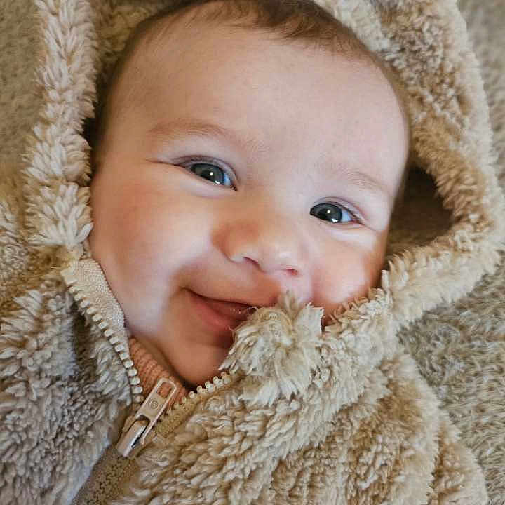 Madeva participe au concours pour gagner de l'argent avec cette photo : apparel, baby, child, closeup, cute, eyes, face, fluffy, happy, hood, infant, jacket, person, portrait, skin, smiling, soft, texture, warm, zipped