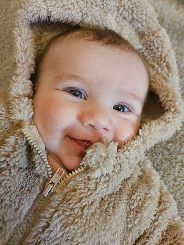 Madeva participe au concours pour gagner de l'argent avec cette photo : baby, smiling, face, hood, jacket, fluffy, closeup, portrait, child, cute, warm, soft, apparel, zipped, infant, happy, person, skin, eyes, texture