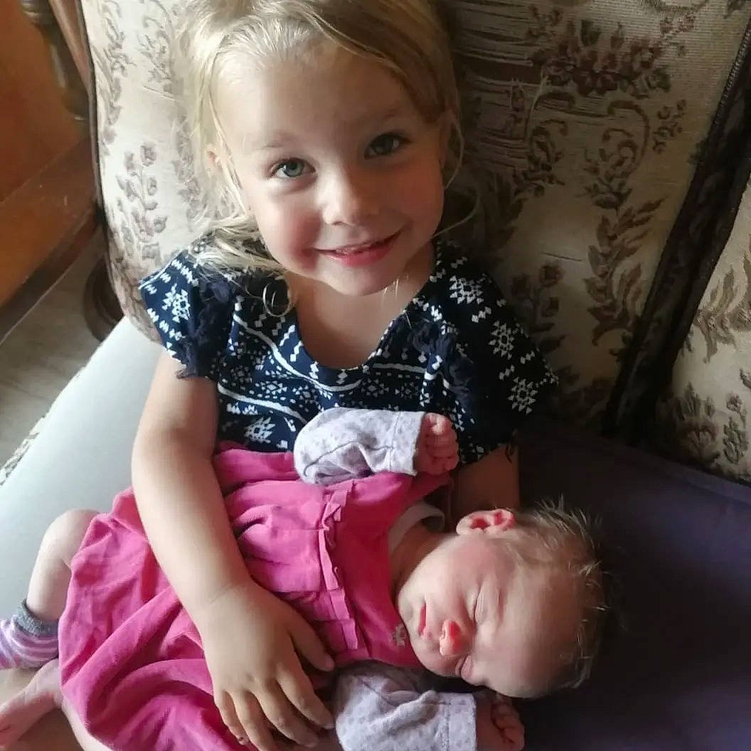 Flavie Et Hanaë a rejoint le concours — aidez-le/la à gagner de superbes lots ! baby, baby_toddler_clothing, blond, cheek, child, chin, comfort, dress, eye, eyelash, face, happy, iris, joy, lip, pattern, person, sitting, skin, sleeve