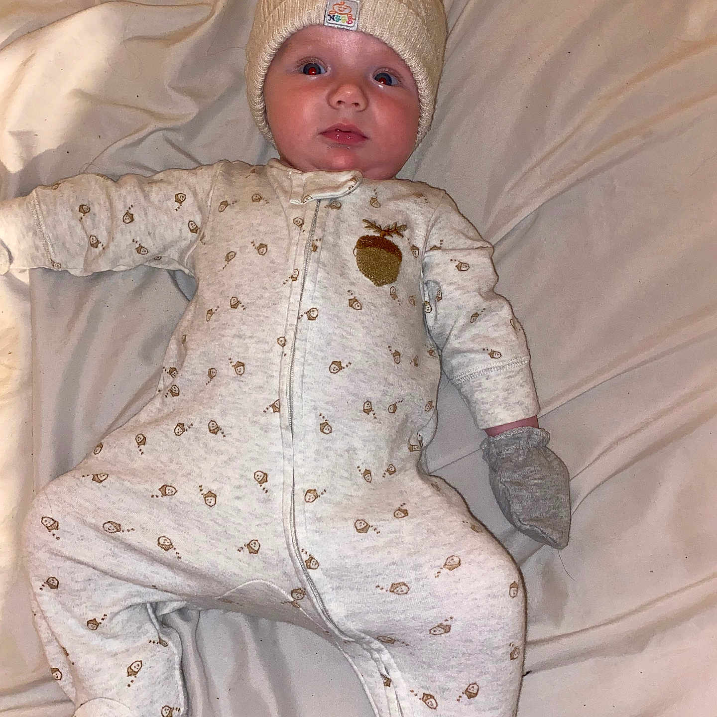 Bryan is registered to the contest to win money with this photo: baby, beanie, bed, bodypart, bonnet, cap, clothing, face, finger, furniture, glove, hand, hat, head, newborn, pajamas, pants, person, photography, portrait