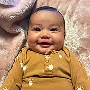 Nevaeh joined the competition — help win amazing prizes! baby, smiling, infant, face, eyes, blanket, brown_clothing, patterned_clothing, happy, cute, portrait, indoor, soft_texture, cozy, child, young, person, head, skin, eyebrows