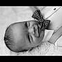 baby, infant, smile, face, bow_tie, black_and_white, portrait, close_up, clothing, suspenders, cute, happy, lying_down, fluffy_surface, head, skin, young_child, one_person, indoors, monochrome