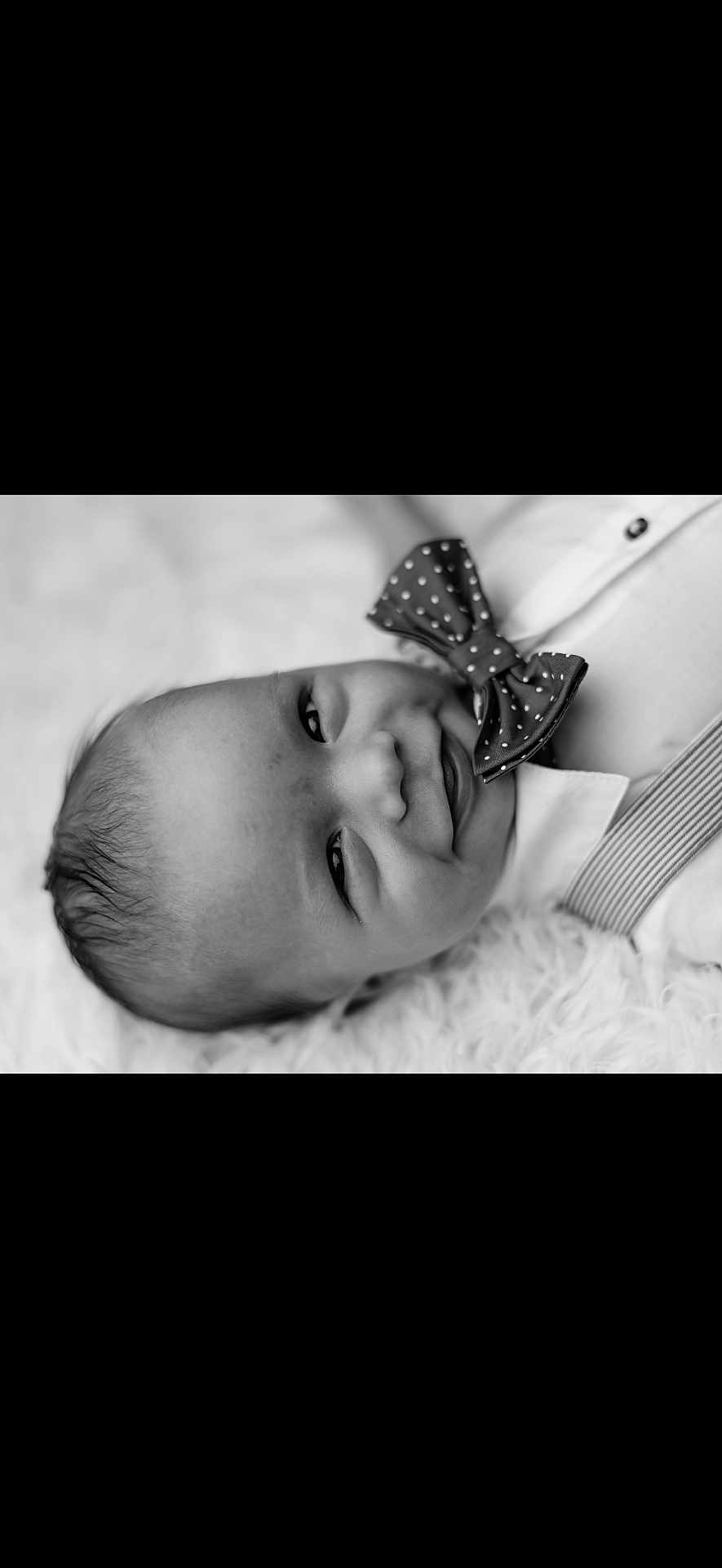 Kasen joined the competition — help win amazing prizes! baby, infant, smile, face, bow_tie, black_and_white, portrait, close_up, clothing, suspenders, cute, happy, lying_down, fluffy_surface, head, skin, young_child, one_person, indoors, monochrome