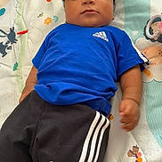 Wayson a rejoint le concours — aidez-le/la à gagner de superbes lots ! baby, infant, child, baby_boy, blue_shirt, adidas_logo, sports_shorts, striped_shorts, curly_hair, play_mat, patterned_blanket, lying_down, looking_at_camera, portrait, indoor, soft_toys, colorful, bare_arms, small_hand, relaxed_expression
