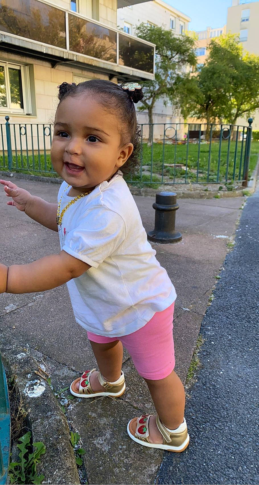 Camillia participe au concours pour gagner de l'argent avec cette photo : asphalt, baby_toddler_clothing, facial_expression, fun, grass, hairstyle, happy, leaf, leisure, person, pink, plant, recreation, sandal, shorts, smile, spring, standing, toddler, tree