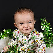 Levi joined the competition — help win amazing prizes! baby, infant, smiling, portrait, face, eyes, onesie, clover_pattern, rainbow, stars, green_tinsel, tinsel, holiday_decor, cute, cheerful, studio_background, closeup, sitting, hands, sparkle