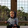 Levi joined the competition — help win amazing prizes! child, toddler, baby, hoodie, jacket, sitting, barefoot, wooden_deck, railing, wire_fence, palm_trees, pond, outdoors, portrait, expression, tongue_out, casual_clothing, smile, hands, feet