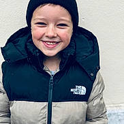 Hugo a rejoint le concours — aidez-le/la à gagner de superbes lots ! child, smiling, boy, jacket, beanie, hat, winter_clothing, north_face, outdoor, portrait, happy, face, headwear, casual, young, cute, warm_clothes, person, standing, casual_wear