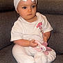 baby, child, pacifier, headband, bow, white_clothing, sitting, couch, indoor, cute, infant, toy, expressionless, person, pink, fabric, sock, minnie_mouse, accessory, soft
