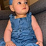 baby, child, denim, blue, headband, romper, sitting, couch, indoors, foot, hand, face, skin, curious, expression, furniture, soft, casual, portrait, infant