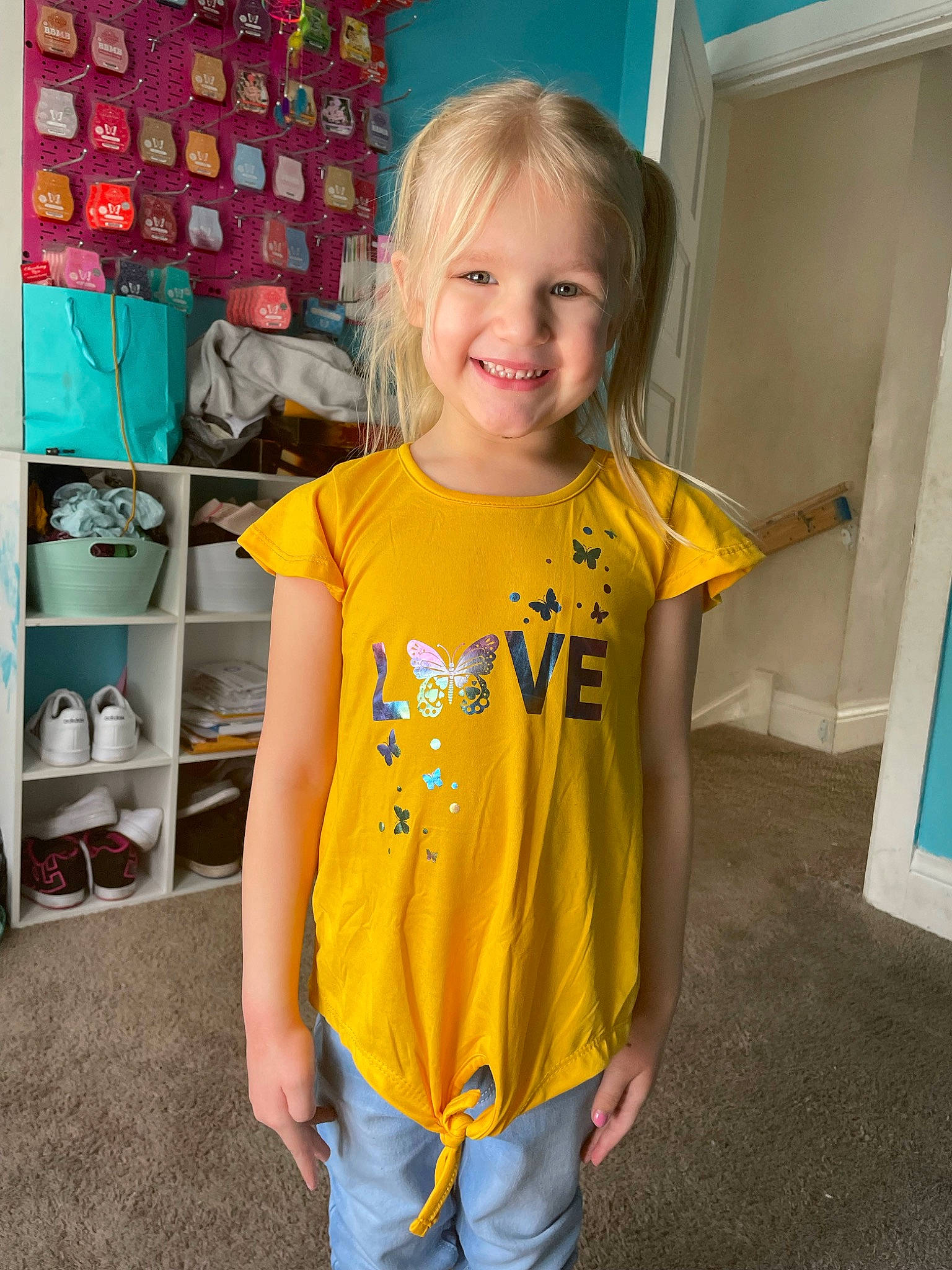 Remington is registered to the contest to win money with this photo: blond, child, electric_blue, eye, face, facial_expression, flooring, fun, happy, joy, pattern, person, room, shoulder, sleeve, smile, sportswear, t_shirt, textile, toddler
