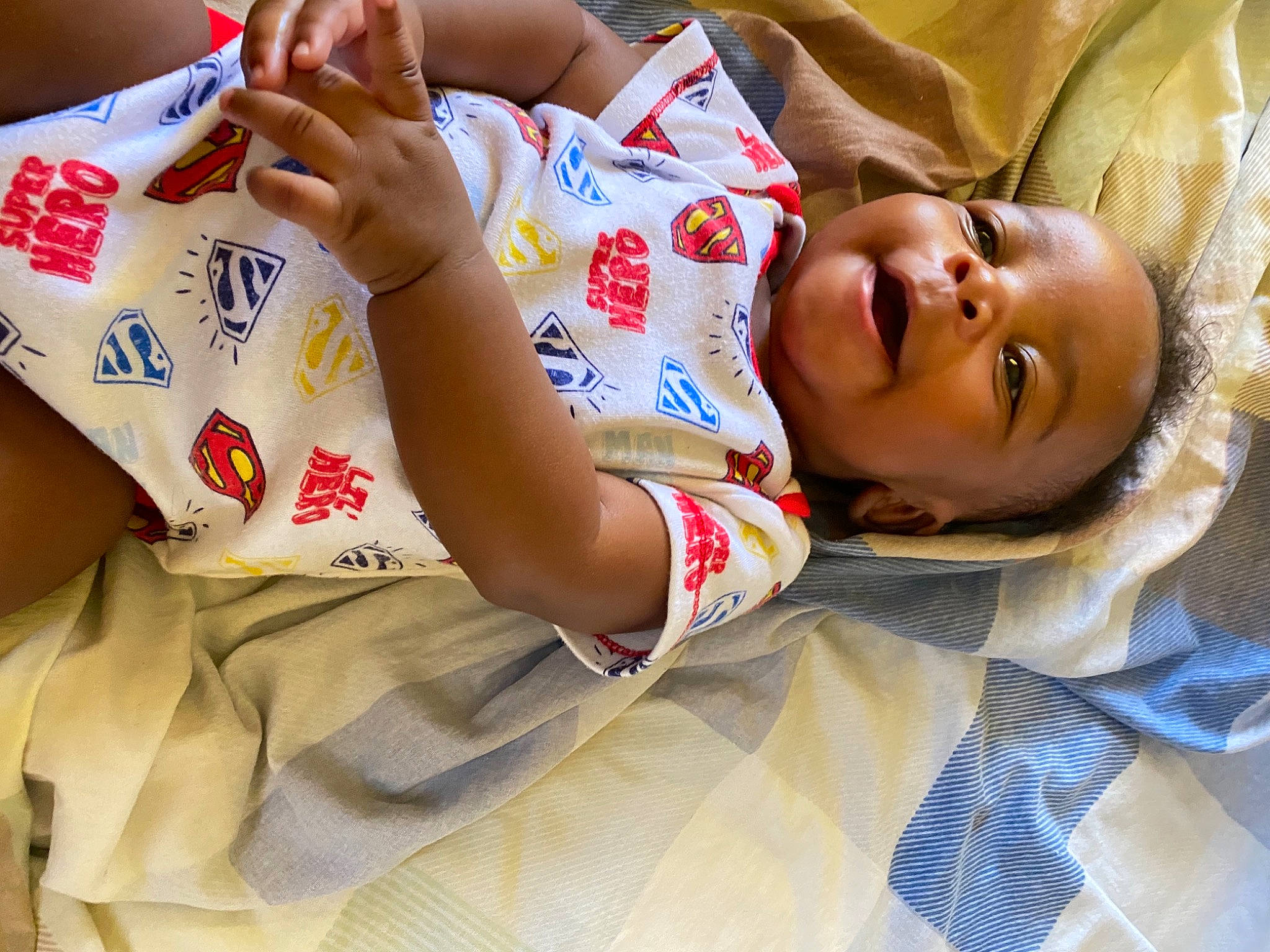 Ayaan is registered to the contest to win money with this photo: abdomen, arm, baby, baby_toddler_clothing, carmine, child, comfort, elbow, finger, flesh, hand, happy, human_leg, linens, nail, pattern, person, skin, sleeve, thigh