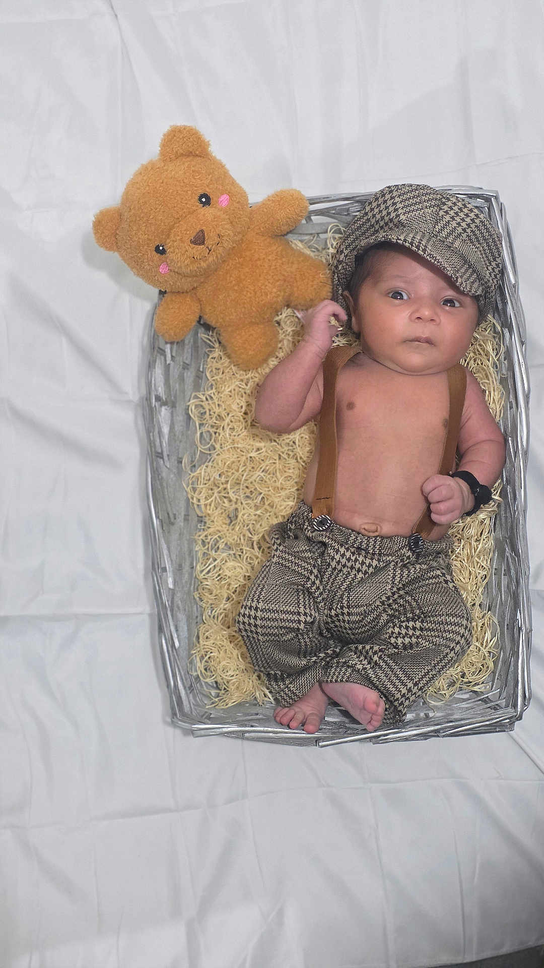 Evaan joined the competition — help win amazing prizes! baby, infant, basket, teddy_bear, hat, clothing, suspenders, fabric, cute, portrait, newborn, toy, soft_toy, feet, hand, face, expression, indoor, blanket, comfort