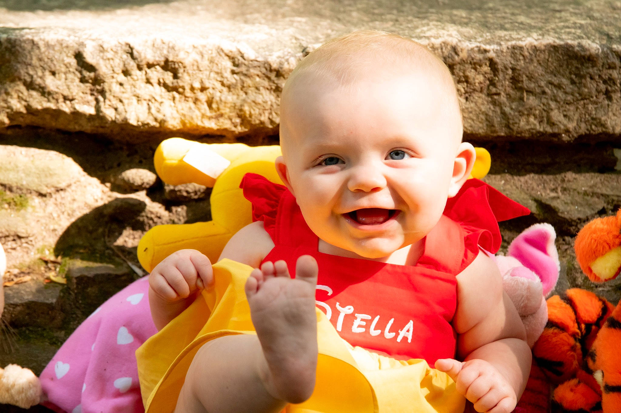 Stella James is registered to the contest to win money with this photo: baby_laughing, baby_toddler_clothing, eye, finger, fun, gesture, grass, hand, happy, human_body, leisure, orange, people_in_nature, person, plant, recreation, smile, t_shirt, thumb, toddler