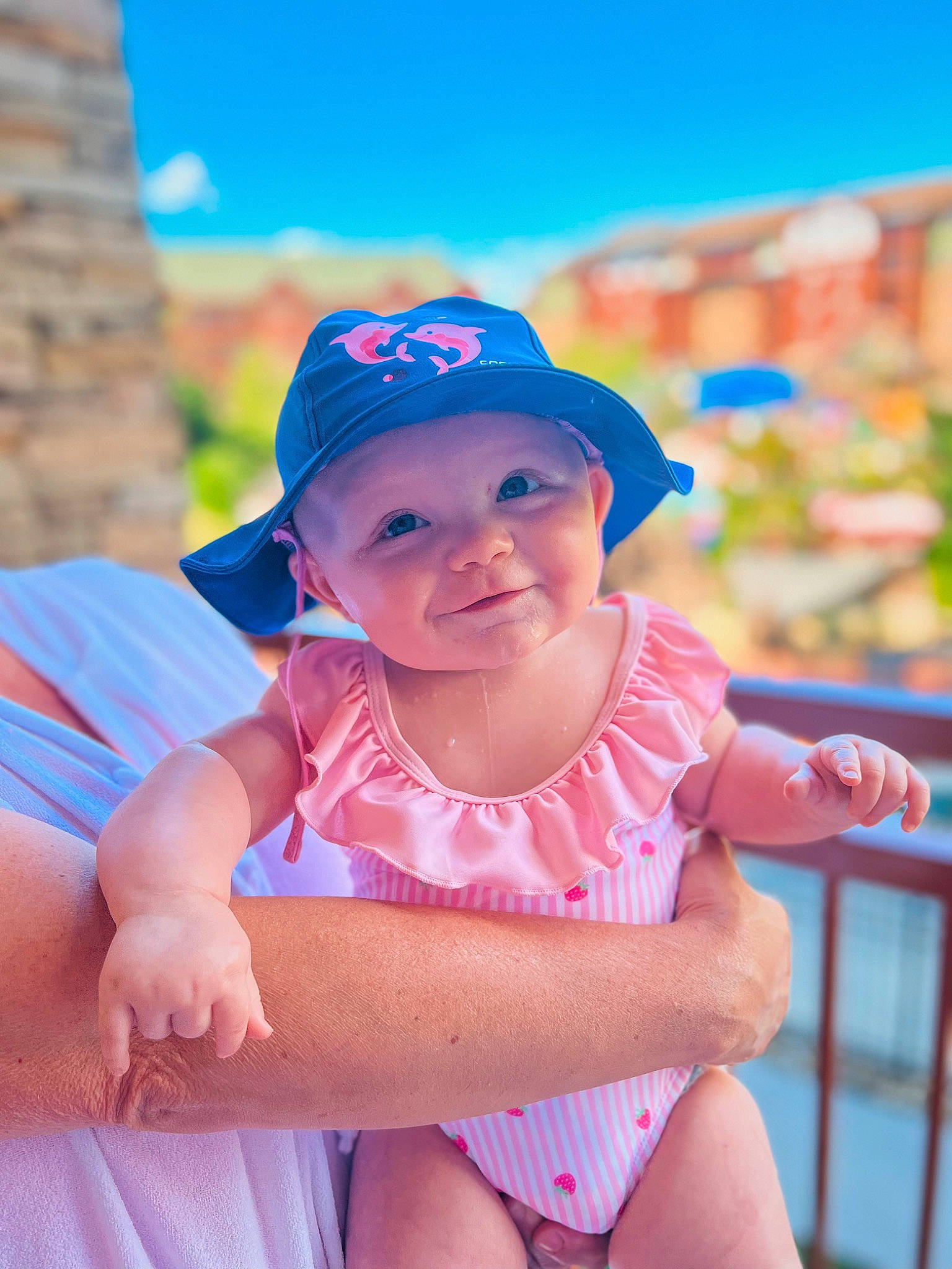 Stella James is registered to the contest to win money with this photo: baby_toddler_clothing, baseball_cap, body_of_water, cap, eye, face, facial_expression, fun, happy, hat, headgear, headwear, human_body, leisure, person, pink, skin, sky, smile, sun_hat