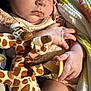 baby, sleeping, plush_toy, giraffe, pacifier, blanket, infant, hand, face, peaceful, child, soft_light, wrapped, cute, cozy, resting, closeup, skin, fingers, toddler