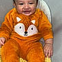 Alejando Noriega joined the competition — help win amazing prizes! baby, child, smile, orange_onesie, fox_design, chair, blanket, happy, cozy, cute, infant, clothing, footwear, indoors, portrait, sitting, fuzzy_texture, warm, comfortable, person