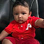 Alejando Noriega joined the competition — help win amazing prizes! toddler, child, red_clothing, shorts, polo_shirt, necklace, cross, leather_chair, barefoot, serious_expression, indoor, portrait, person, cute, baby, sitting, young_child, skin, hair, face