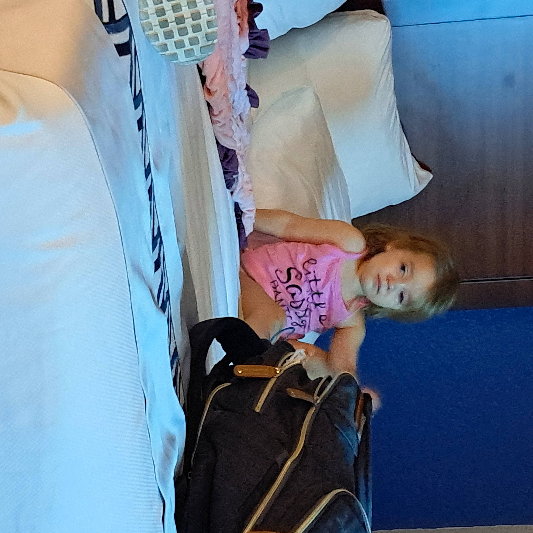 Hermione is registered to the contest to win money with this photo: backpack, beauty, bedding, child, comfort, elbow, fun, hairstyle, human, joint, leisure, linens, luggage_and_bags, person, product, room, shoulder, sitting, t_shirt, toddler