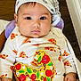 baby, infant, bandana, pizza_pattern, clothing, cute, child, face, portrait, indoors, hand, sitting, expression, cozy, blanket, wearing, headwear, young, apparel, looking