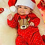 baby, infant, red_onesie, polka_dots, reindeer, santa_hat, christmas, holiday_lights, ornaments, white_blanket, soft_texture, smiling, cute, festive, portrait, indoors, holiday_season, celebration, child, happy