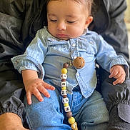 Kenan participe au concours pour gagner de l'argent avec cette photo : baby, beads, casual_clothing, child, closeup, curious, cute, denim_shirt, hand, holding, indoor, jeans, lap, pacifier_clip, person, portrait, relaxed, sitting, soft_lighting, young_child