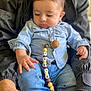 baby, beads, casual_clothing, child, closeup, curious, cute, denim_shirt, hand, holding, indoor, jeans, lap, pacifier_clip, person, portrait, relaxed, sitting, soft_lighting, young_child