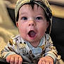 baby, child, cap, pajamas, hands, face, blue_eyes, expression, playpen, crib, indoor, portrait, cute, infant, grip, clothing, young, surprised, headwear, soft_background