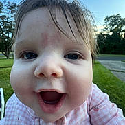 Ariel is registered to the contest to win money with this photo: baby, child, face, close_up, pink_clothing, outdoor, grass, trees, sky, happy, smiling, mouth_open, cute, infant, portrait, young_child, nature, daylight, person, head