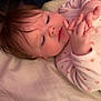 baby, bed, blanket, child, closeup, curious, cute, face, fingers, hair, hand, indoor, infant, lying_down, onesie, person, pink_clothing, skin, sleepwear, soft_lighting