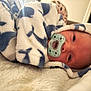 baby, blanket, pacifier, infant, sleepy, soft_texture, cozy, wrapped, face, head, comfort, indoor, closeup, person, newborn, warm, resting, cute, patterned_blanket, lying_down