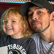 Raylon is registered to the contest to win money with this photo: child, man, smile, portrait, indoor, casual, blonde_hair, cap, chain, facial_hair, person, restaurant, tshirt, happy, closeup, jewelry, family, toddler, table, food_wrapper