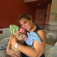 Lisandro participe au concours pour gagner de l'argent avec cette photo : newborn, baby, mother, hospital, bed, hospital_room, woman, infant, striped_clothing, holding, love, family, care, blanket, medical_band, arm_bandage, towel, indoor, portrait, sleeping