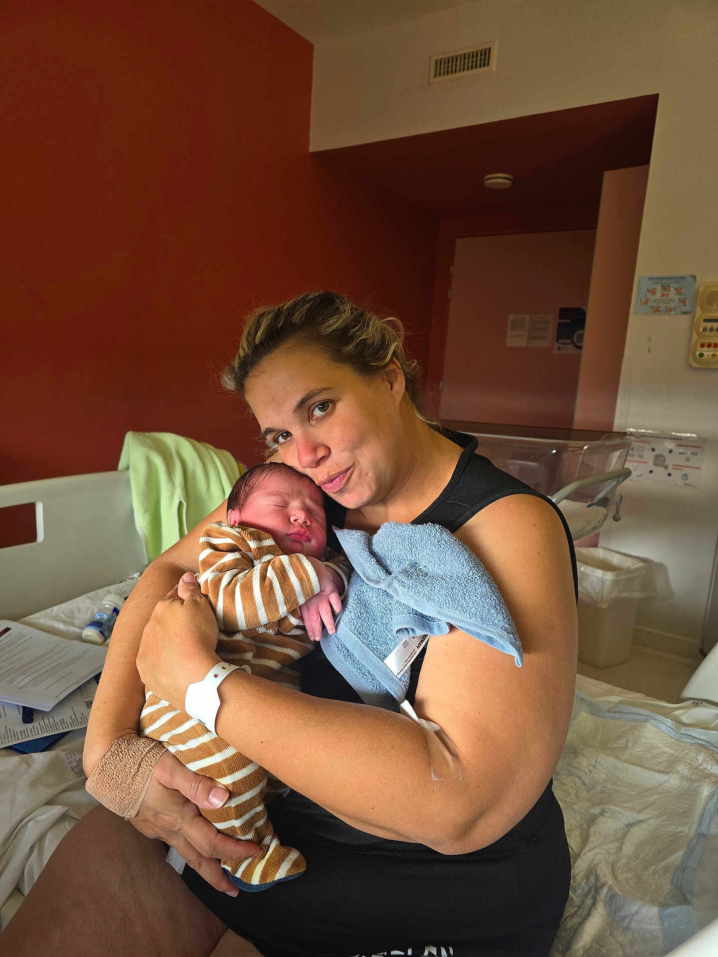 Lisandro participe au concours pour gagner de l'argent avec cette photo : newborn, baby, mother, hospital, bed, hospital_room, woman, infant, striped_clothing, holding, love, family, care, blanket, medical_band, arm_bandage, towel, indoor, portrait, sleeping