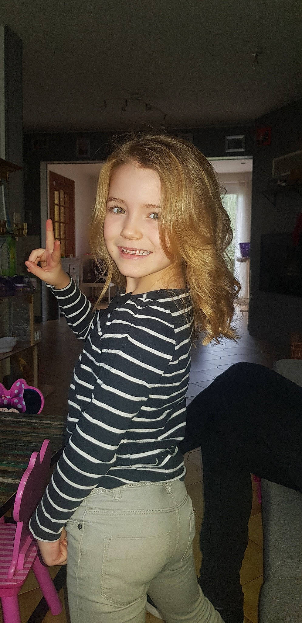 Emmy participe au concours pour gagner de l'argent avec cette photo : arm, blond, brown_hair, child_model, finger, fun, gesture, hair, hairstyle, joy, leg, long_hair, person, shoulder, sleeve, smile, t_shirt